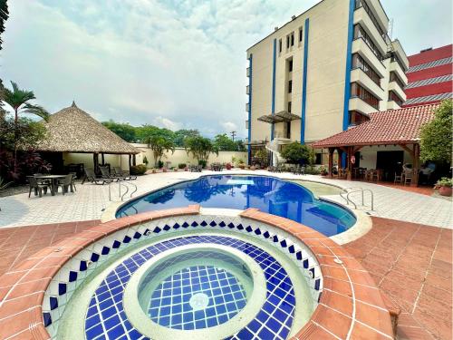 basen w hotelu z budynkiem w tle w obiekcie Hotel Maria Gloria w mieście Villavicencio