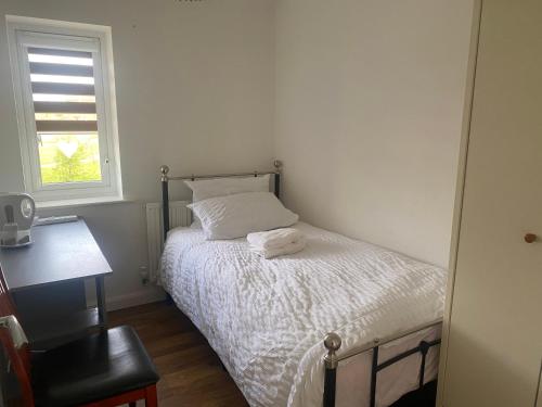 a small bedroom with a bed and a window at C.K. APARTMENT in Foleshill