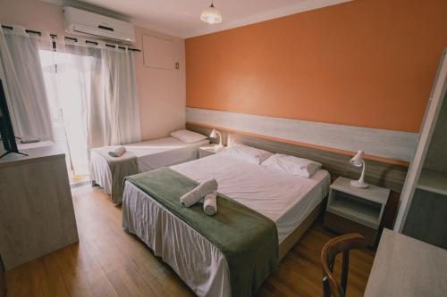 um quarto de hotel com duas camas e uma janela em Pousada Café em Torres