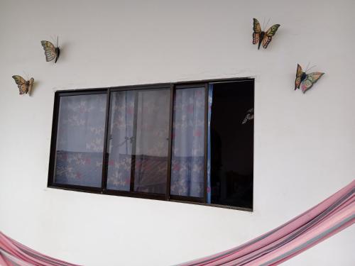 a window with butterflies on the side of a building at Morada Ítaca - Arboletes in Arboletes