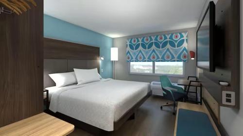 1 dormitorio con 1 cama, 1 silla y 1 ventana en Tru By Hilton Wilmington Mayfaire, en Wilmington