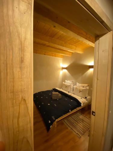 a small bed in a small room with wooden ceilings at Granero Colibita in Colibiţa