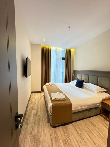 a bedroom with a large bed and a window at New Wave Apart-Hotel in Batumi