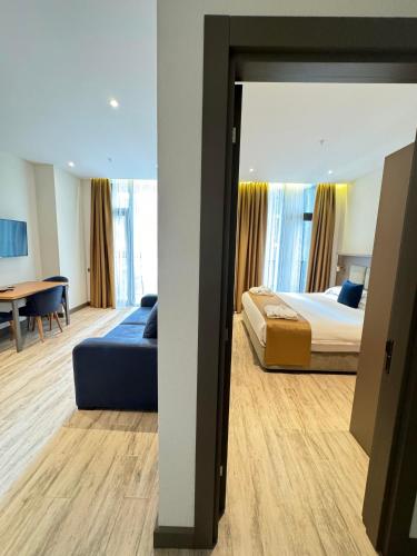a bedroom with a bed and a couch and a table at New Wave Apart-Hotel in Batumi