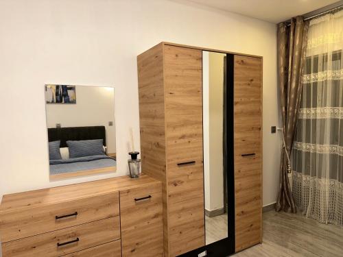 a bedroom with a large wooden dresser and a mirror at SYN - Clairon in Brazzaville
