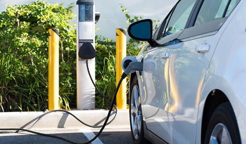 a white car is plugged into a parking meter at Roomie Apartment Hotel in Auckland