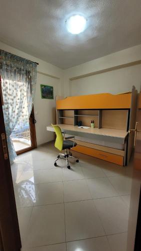 a bedroom with a desk and a yellow chair at Paralia Ofriniou Sea view apartment in Orfánion