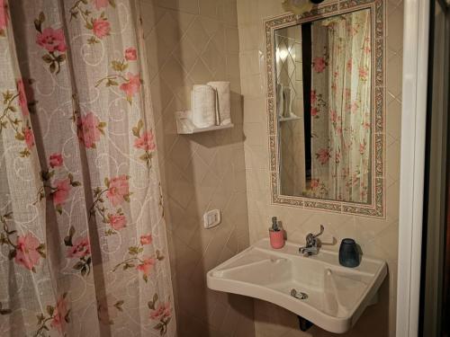 La salle de bains est pourvue d'un lavabo et d'un miroir. dans l'établissement Meriggio, à Catabbio
