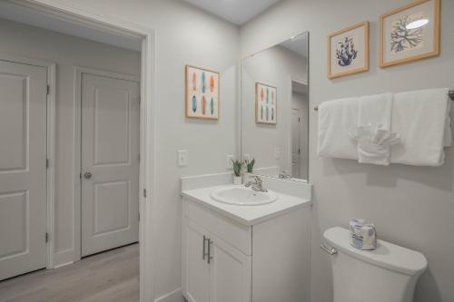a white bathroom with a sink and a toilet at Sea Glass 316 by Vacation Homes Collection in Gulf Shores