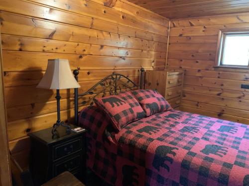 um quarto com uma cama num chalé de madeira em Gresham Shores-Hungry Bear em Arbor Vitae