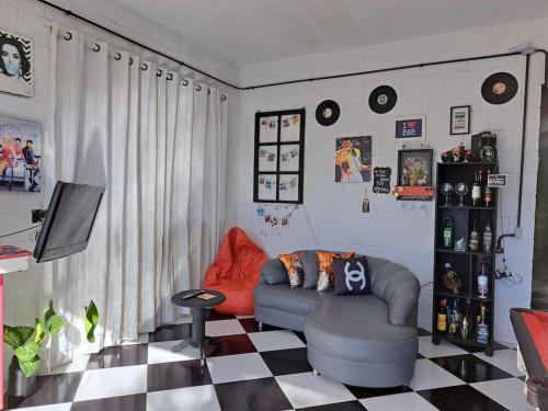 ein Wohnzimmer mit einer Couch und einem Schachbrettboden in der Unterkunft Casa para relaxar, estilosa, privativa e pet friendly in Nazaré Paulista