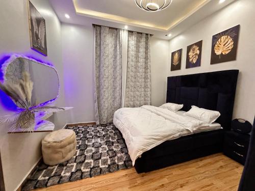 a bedroom with a large bed with a purple light at Lyrrh Homes Apartments in Kira
