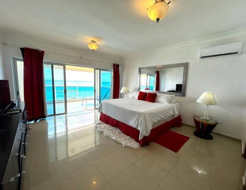 a bedroom with a bed and a view of the ocean at Private beach front Apartment in Juan Dolio in Los Corrales