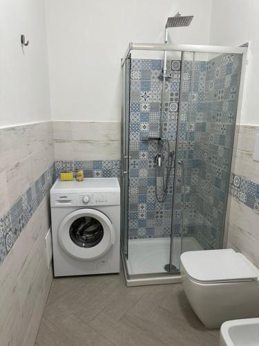 a bathroom with a shower and a washing machine at Rossella GOLD HOUSE in Scauri