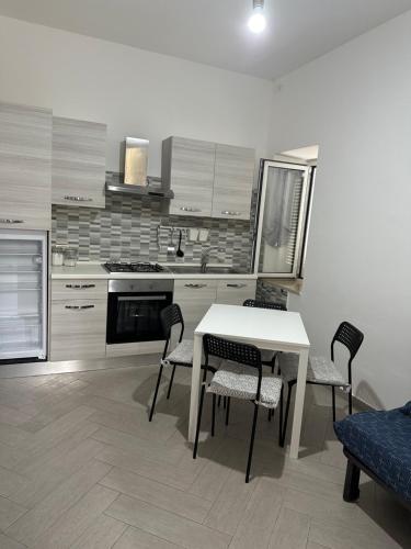 a kitchen with a table and chairs and a stove at Rossella GOLD HOUSE in Scauri