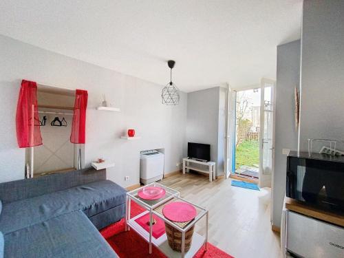 ein Wohnzimmer mit einem Sofa und einem TV in der Unterkunft Studio avec jardin a Corbeil-Essonne in Corbeil-Essonnes