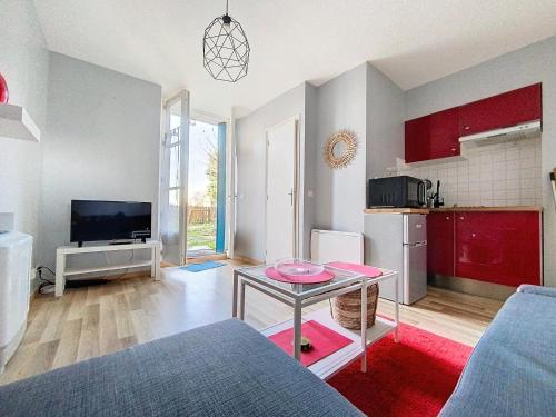 ein Wohnzimmer mit einem Tisch und einer Küche in der Unterkunft Studio avec jardin a Corbeil-Essonne in Corbeil-Essonnes