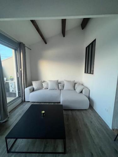 un salon avec un canapé blanc et une table dans l'établissement Appartement terrasse belle vue en duplex parking, à Sète
