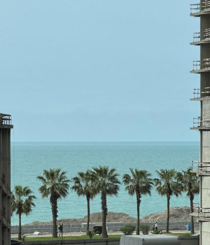 a view of the ocean from a building with palm trees at New Wave Apart-Hotel in Batumi