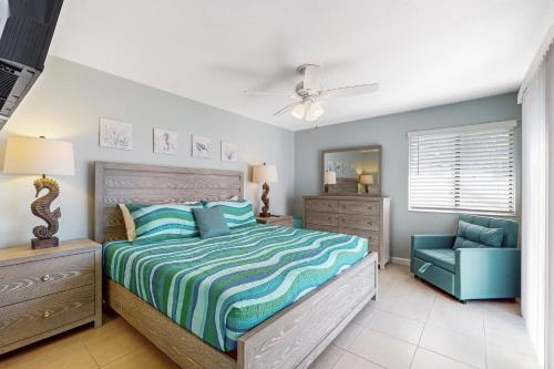 a bedroom with a bed and a blue chair at Centrally located dog-friendly home with beach gear & patio - snowbird-friendly in Palm Coast