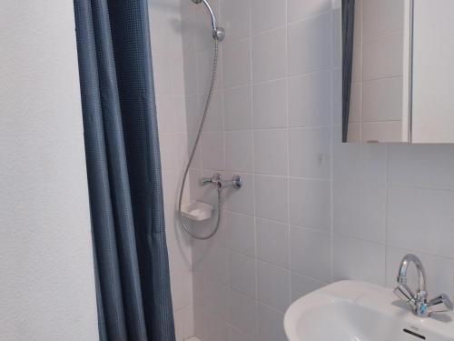 une douche avec un rideau de douche bleu à côté d'un lavabo dans l'établissement Les Chauvets, à Langogne