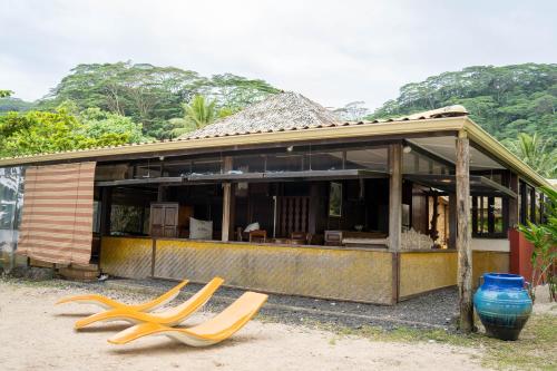 a house with two yellow chairs in front of it at LE ROCHER DE TAHITI in Mariuti