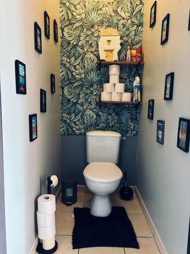 La salle de bains est pourvue de toilettes et d'un mur orné de plantes. dans l'établissement T2 moderne, Festival Avignon en été, à Avignon