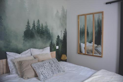 um quarto com uma cama com um quadro na parede em Domaine des cyprès em Vaudrimesnil
