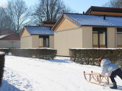 a person is playing with a sled in the snow at Holiday Home in Zevenhuizen with Sauna in Zevenhuizen