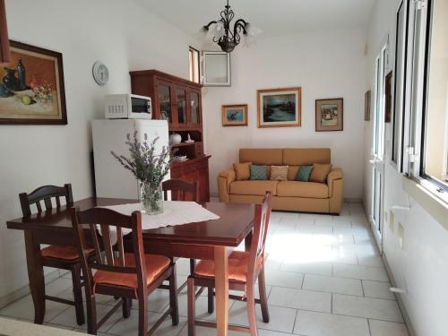 uma cozinha e sala de estar com mesa e cadeiras em Casetta del’600 in antico ortale salentino em Maglie