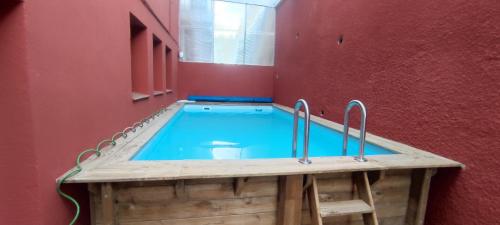 una piscina en una habitación con una pared roja en ESTUDIO COMPLETO FAMILIAR, en La Jonquera