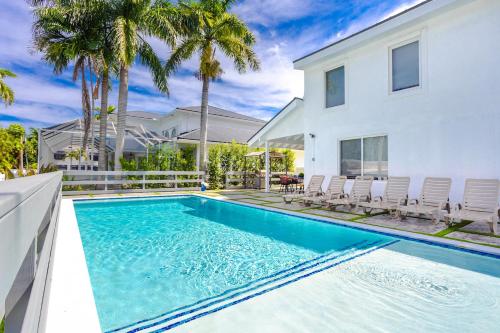 ein Swimmingpool vor einem Haus mit Palmen in der Unterkunft Luxury 5BR & 3BA Villa Walk to Hollywood Beach in Hollywood