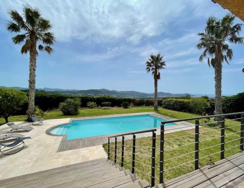 une piscine dans une cour avec des palmiers dans l'établissement Villa superbe vue mer calme sans vis-à-vis, à Laouque