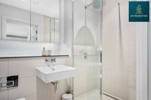 uma casa de banho branca com um lavatório e um chuveiro em Stylish 2 Bedroom Apartment em Manchester