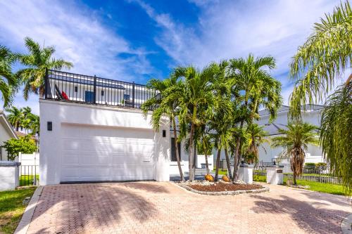 eine weiße Garage mit Palmen davor in der Unterkunft Luxury 5BR & 3BA Villa Walk to Hollywood Beach in Hollywood