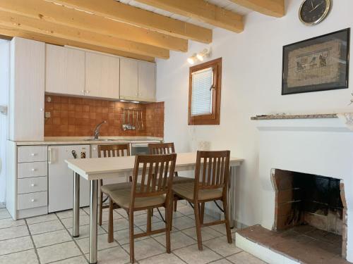 une cuisine avec une table et des chaises ainsi qu'une cheminée dans l'établissement Pirinas Meteora, à Kalambaka