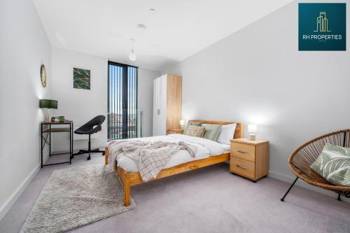 um quarto com uma cama, uma secretária e uma cadeira em Stylish 2 Bedroom Apartment em Manchester