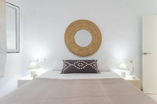 una camera da letto con un letto con uno specchio sul muro di Chalet independiente a 50 metros de Cala Blanca a Jávea