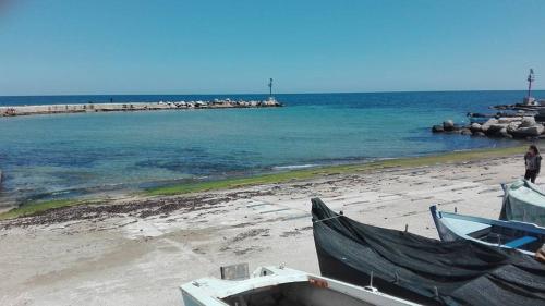dois barcos sentados numa praia com o oceano em Casa di Monique 1 em Bari Palese