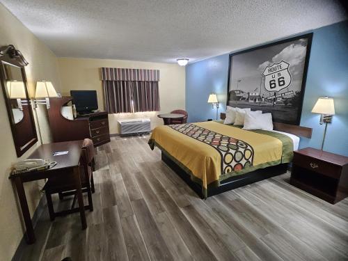 a hotel room with a bed and a desk at Super 8 by Wyndham Clinton in Clinton
