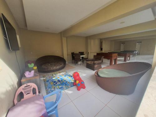 a living room with a tub and a dining room at Pousada Porto das Dunas in Aquiraz