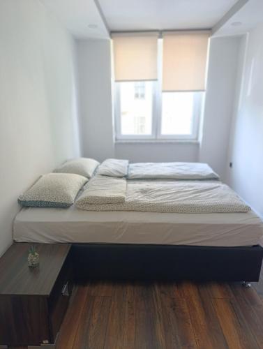 Ce lit se trouve dans un dortoir doté de parquet. dans l'établissement Apartman Erin, à Sarajevo