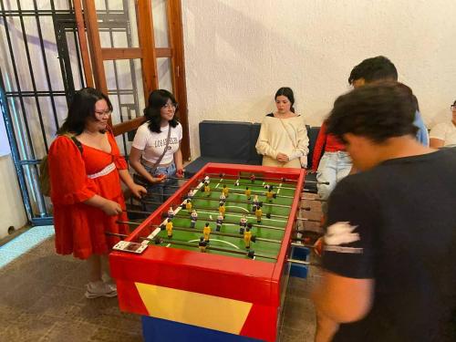 un grupo de personas de pie alrededor de una mesa de futbolín en Hotel Dulce Luna, en San Cristóbal de Las Casas
