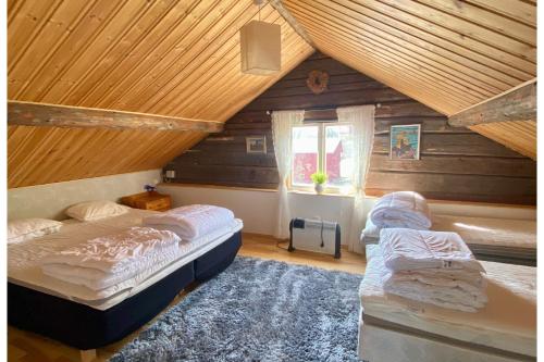een slaapkamer met 2 bedden op een zolder bij Tömsagården in Järvsö