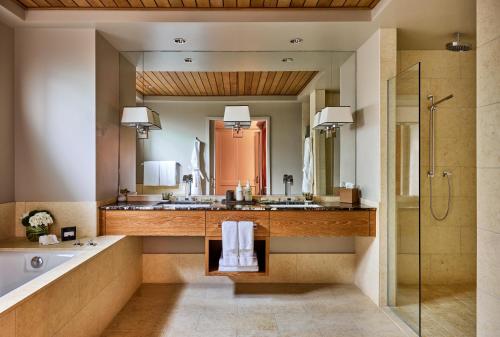 a bathroom with a tub and a large mirror at Rosewood Sand Hill in Menlo Park