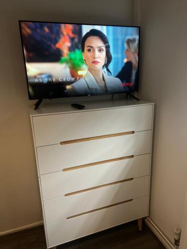 una TV a schermo piatto seduta sopra un comò di Serene Escape a Monmore Green
