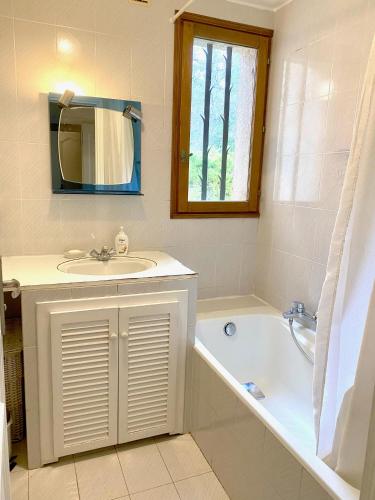 une salle de bain avec un lavabo, une baignoire et un miroir dans l'établissement Air-conditioned villa with fresh eggs & vegetables, à Roquefort-les-Pins