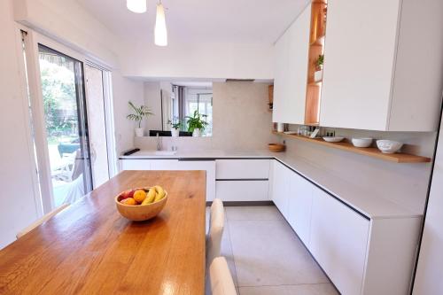 - une cuisine avec un bol de fruits sur une table en bois dans l'établissement Air-conditioned villa with fresh eggs & vegetables, à Roquefort-les-Pins