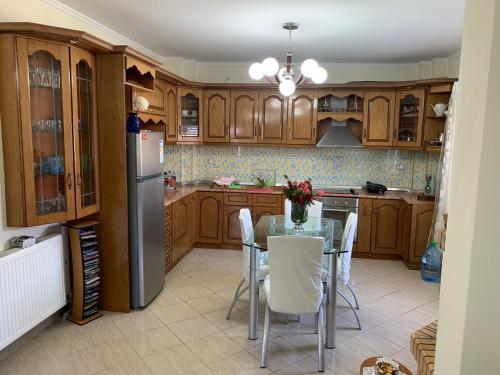 a kitchen with a glass table and a refrigerator at A 3-floor building with 4 bedroom near beach in Fier