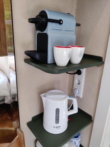 a coffee maker and two cups on shelves at House of Straw Amsterdam in Amsterdam